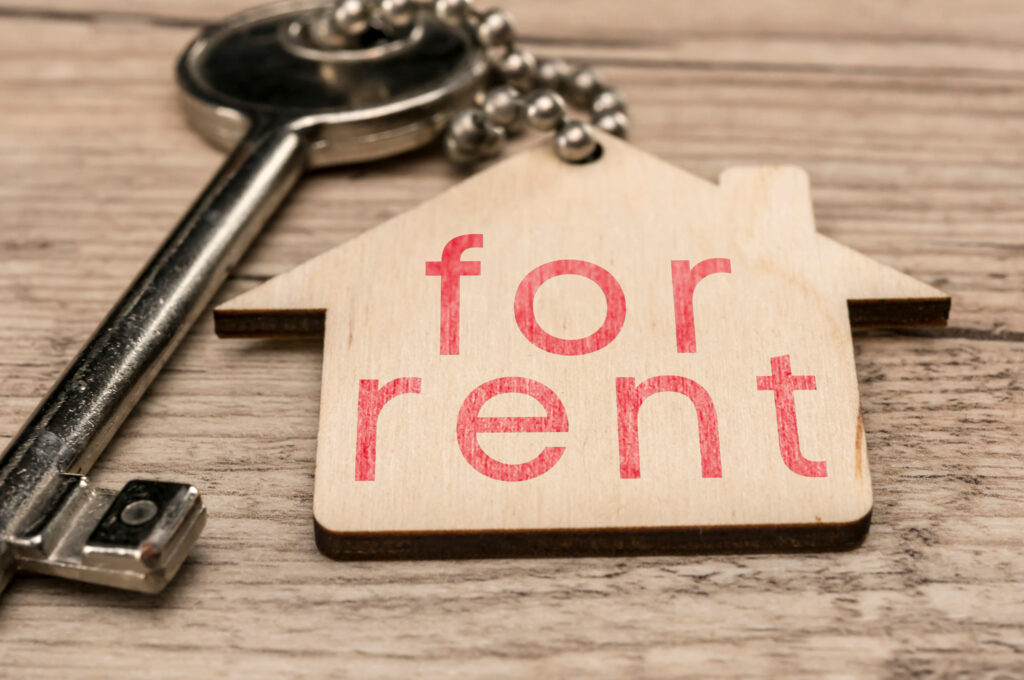 Key and wooden house-shaped tag with "for rent" text, symbolizing rental property management and landlord considerations in Ontario.