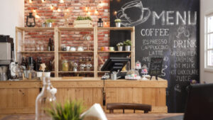 Coffee shop interior featuring a rustic wooden counter, chalkboard menu with drink options, and warm brick wall decor, relevant to Guelph's local coffee scene.