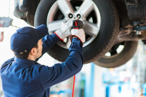 Mechanic working on a car wheel in an auto repair shop, highlighting quality service for Guelph residents.