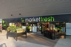 Market Fresh grocery store exterior with vibrant signage and outdoor display of fresh produce, highlighting local shopping options in Guelph.